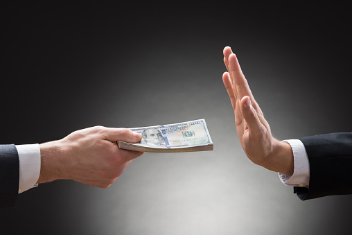 Close-up Of Businessman Hand Rejecting The Money Offered By Other Businessman